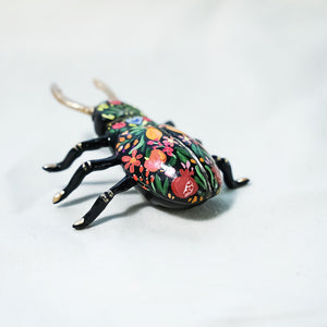 Black beetle with citrus and flowers