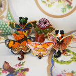Calico cat with butterfly wings and strawberry sweater