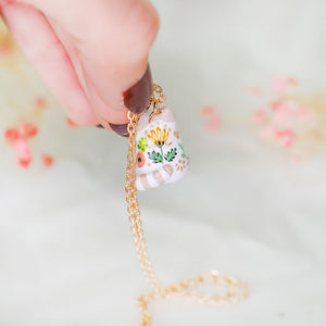 White cat with colorful flowers pendant