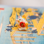 Maneki neko with a flower pendant