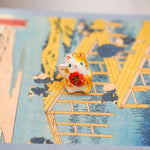 Maneki neko with a flower pendant