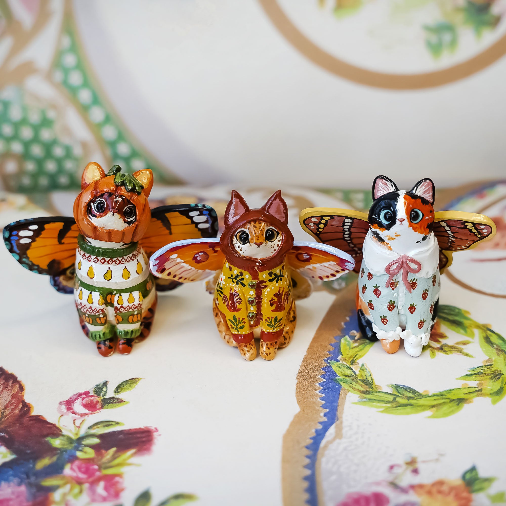 Calico cat with butterfly wings and strawberry sweater