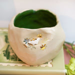 Ceramic flower pot with a stegosaurus
