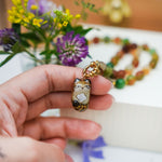 Pallas Cat with a mother-of-pearl pendant