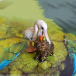 Pelican eating capybara figurine