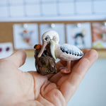 Pelican eating capybara figurine