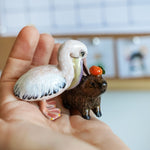 Pelican eating capybara figurine