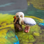 Pelican eating capybara figurine