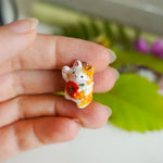 Maneki neko with a flower pendant