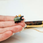 Rhinoceros beetle with a gold star pendant