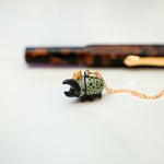Rhinoceros beetle with a gold star pendant