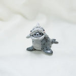 Seal with hats (penguin and shark) figurine