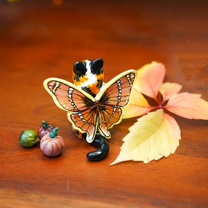 Calico cat with butterfly wings and strawberry sweater