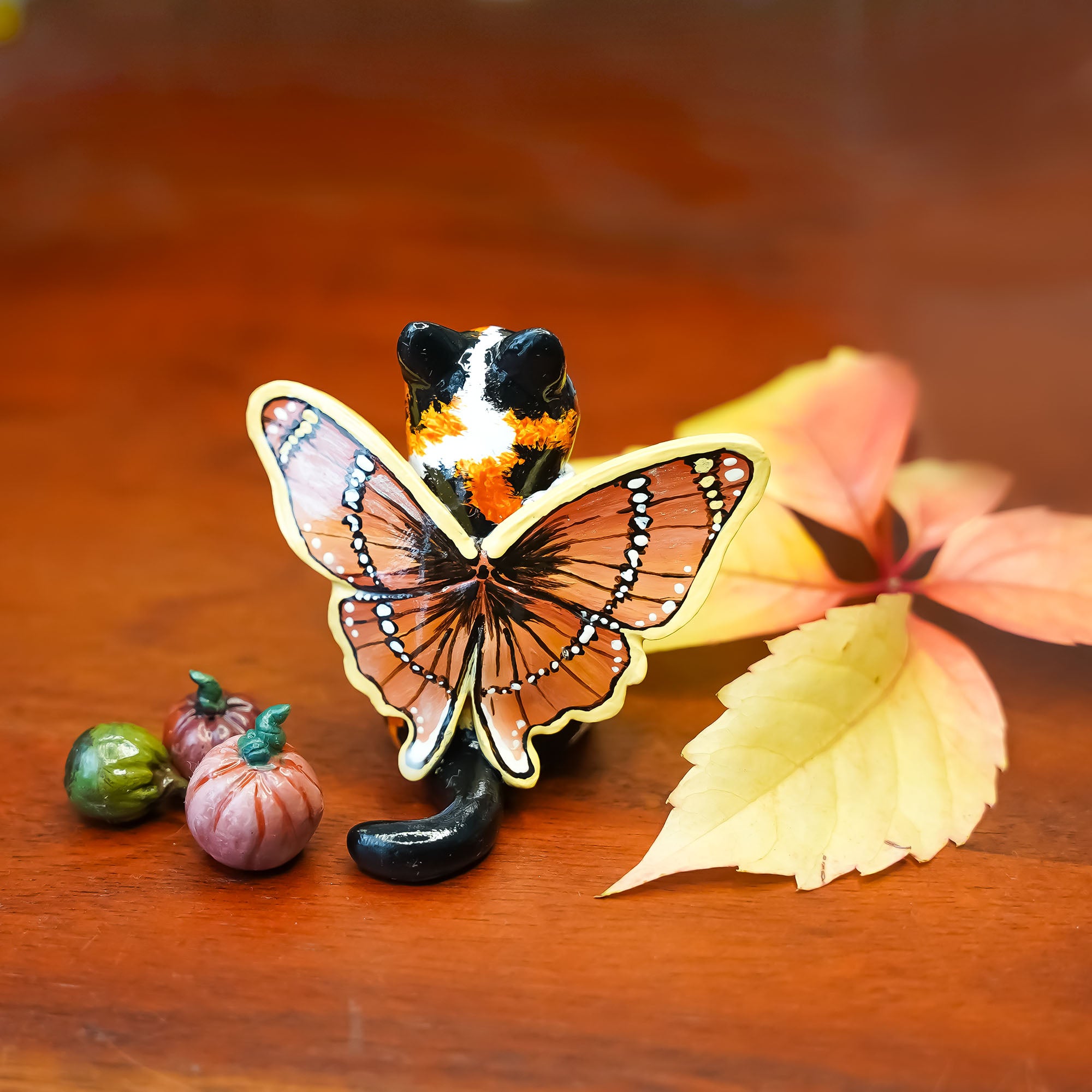 Calico cat with butterfly wings and strawberry sweater