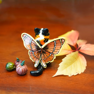 Calico cat with butterfly wings and strawberry sweater